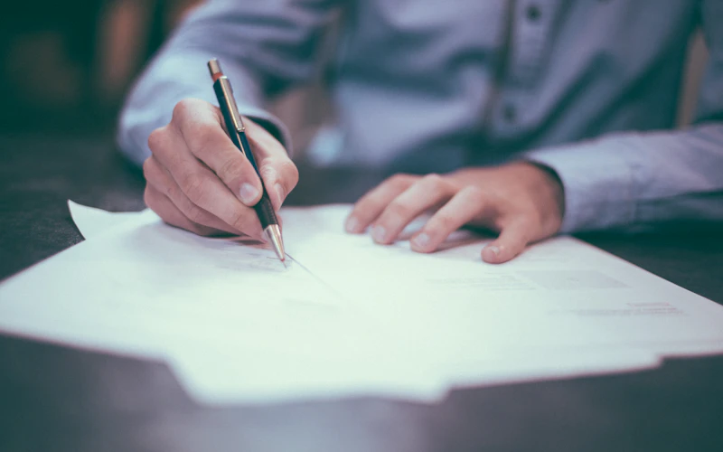 Hand schreibt mit Füller auf Papier